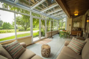 adding a sunroom like this gorgeous white sunroom facing a landscape is perfect to amp up your home's financial value